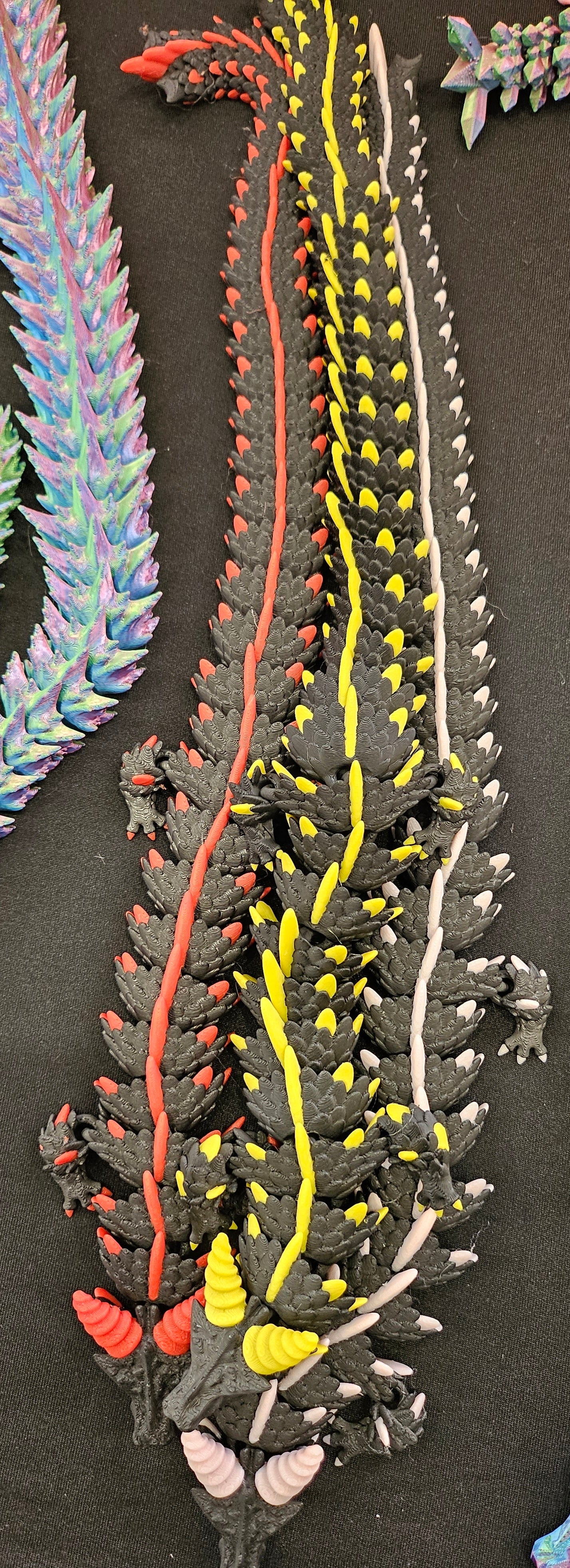 3D printed articulated dragon with multi-colour spines, side view